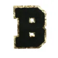 Close-up of black chenille letter B patch with shiny gold glitter border for DIY apparel. - Letter B