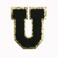 Close-up detail of the black and gold glitter letter U patch, textured chenille embroidery. - Letter U