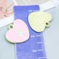 Pendentif cœur en alliage émaillé rose avec fleur et texte GET ME présenté sur règle - Fleur de Cœur (27215)