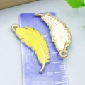 Two yellow enamel and gold feather charms for DIY jewelry making on purple ruler - 1 Piece (30x11mm)