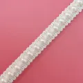Close-up detail of white pearl lace trim ribbon, perfect for DIY crafts and accessories. - Style 1