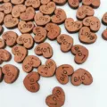 Close-up detail view of small wooden heart buttons with engraved love text for DIY crafts. - 100 Pieces/Pack / Dark Coffee