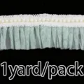 Detail view of green ruffled mesh lace trim with pearls, ideal for wedding dress sewing. - Light Green