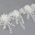 Detailed view of white lace trim with chiffon flowers and pearls, ideal for crafts and sewing. - White