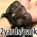 Close-up detail of black pleated lace trim wrapped on wrist for DIY sewing crafts. - Black