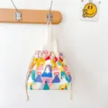 Close up view of colorful cartoon house pattern canvas drawstring bento bag detail. - Dreamy Castle Drawstring Lunch Bag
