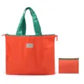 Grand sac cabas pliable orange avec anses vertes et une petite pochette de rangement pratique. - Orange