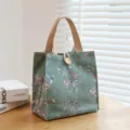 Green floral canvas lunch bag with wooden button closure and durable tote handles for daily use. - Buttons Green Plum Blossom