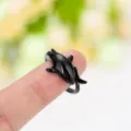 Gros plan détaillé d'une bague requin noire vintage en alliage sur un doigt - Noir Électrophorétique