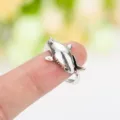 Détail d'une bague enveloppante en forme de requin argenté vintage portée sur un doigt. - Argent Antique