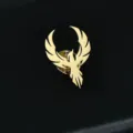 Primer plano de pin de fénix dorado con textura detallada de alas y un brillo metálico - Dorado