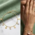 Feines, 18 Karat vergoldetes Edelstahlarmband mit zarten Blumen- und Strassanhängern. - Blumenanhänger / Gold