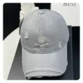 Grey distressed baseball cap detail featuring embroidered letters and vintage washed fabric. - Light Gray