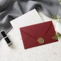 Set di busta rossa testurizzata e biglietto bianco con sigillo in cera dorata per auguri. - Cartolina bianca (1 busta in lino bordeaux + 1 cartolina + 1 sigillo in ceralacca)