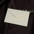 Gedetailleerde close-up van gestructureerde beige envelop, elegante briefpapier op zijde. - 130g linnenstructuur - linnenwit