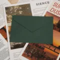 Détail d'enveloppe texturée vert foncé montrant un grain de papier fin et un rabat triangulaire. - Vert Foncé