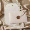 Gros plan sur un élégant set de papeterie avec papier à lettres doré et enveloppe cachet. - 3 enveloppes en lin blanc + 10 papiers à lettres lapin blanc + 3 sceaux de cire
