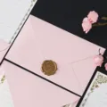Enveloppe rose et ensemble de papeterie détail avec sceau de cire doré et bordure florale. - 1 enveloppe rose clair + 1 sceau de cire bronze