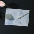 Gros plan détaillé de l'enveloppe rétro bleue marbrée montrant sa texture dorée gaufrée. - 1 enveloppe bleu lac
