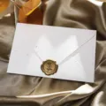 Gros plan détaillé d'une enveloppe en papier rétro moucheté avec sceau de cire rose dorée. - 1 enveloppe dorée mouchetée + 1 sceau de cire (modèle rose)