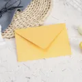 Detailed close-up of a stylish yellow shimmer paper envelope on a textured background. - Gold Yellow