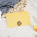 Detailed view of the elegant yellow envelope set with a vintage wax seal and decorative props. - Golden Yellow with 1 Bronze Wax Seal / Golden