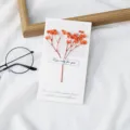 Handgemaakte gedroogde bloemen wenskaart met elegant oranje bloemendesign als prachtig cadeau. - Oranje Gipskruid