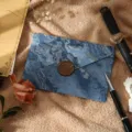 Ensemble d'enveloppes et de papeterie dorées avec texture marbrée et sceau de cire. - 1 enveloppe bleu mer dorée avec 1 sceau de cire (matériau de cire à cacheter)
