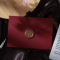 Detailed shot of retro red linen textured envelope with golden wax seal, elegant stationery. - Linen Dark Red Envelope 1pc + Wax Seal