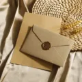 Exquisites Detailbild von Briefumschlag und Briefpapier in Jute-Optik, Vintage-Stil. - 3 graue Leinenumschläge + 10 Blatt liniertes Kraftpapier + 3 Wachssiegel