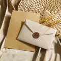 Nahaufnahme der Vintage-Leinenstruktur-Umschläge und linierten Briefpapiere mit Wachssiegelstempel. - 5 weiße Leinenumschläge + 10 Blatt liniertes Kraftpapier + 5 Wachssiegel