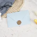 Light blue envelope set detail shot featuring a delicate gold wax seal and paper stationery. - Light Blue with 1 Bronze Wax Seal / Light Blue