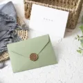 Vista dettagliata di busta verde e biglietto di auguri con sigillo in ceralacca e carta strutturata. - Set da 1 Pezzo (1 Busta + 1 Biglietto + 1 Sigillo in Cera) / Verde avocado