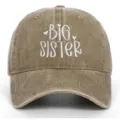 Detailopname van het witte Big Sister borduursel op een gewassen bruine katoenen baseballpet. - Verstelbaar / Big Sister Geborduurd Stijl / Khaki
