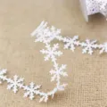 White snowflake ribbon detail, close-up view of holiday gift wrapping trim craft. - White