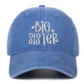 Detailopname van het witte BIG SISTER borduursel op een blauwe gewassen denim honkbalpet - Verstelbaar / Big Sister Geborduurd Stijl / Lichtblauw
