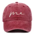 Detail view of a maroon washed cotton baseball cap with white 'me' cursive embroidery - Adjustable / Burgundy