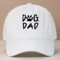 White cotton baseball cap featuring black 'DOG DAD' embroidery with a paw print design - Adjustable / White