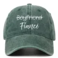 Close-up of Fiance and crossed-out Boyfriend embroidery on washed green baseball cap. - Adjustable / Grass Green (Fiance)