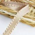 Ruffled satin ribbon detail view, elegant pleated edge design for gift wrapping and crafts. - Champagne