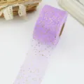 Lila Tüllband Rolle mit goldenen Sternen, Detailaufnahme für Geschenkverpackung. - Hellviolett