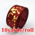 Detailed view of dark red gold foil marble pattern satin ribbon roll, 2.5cm width packaging. - Burgundy