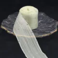 Detailansicht einer 4cm Strass-Netzbandrolle auf Glasteller, ideal zum Verpacken von Geschenken. - Beige