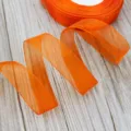 Orange organza ribbon roll for gift wrapping and floral packaging, smooth sheer fabric. - Orange