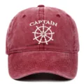 Detailed close-up showing white Captain embroidery and ship wheel on a red washed cotton cap - Adjustable / Burgundy