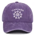 Front view of purple washed cotton baseball cap with white CAPTAIN embroidery and ship wheel - Adjustable / Purple