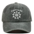 Macro view of white Captain embroidery and nautical wheel on washed grey baseball cap - Adjustable / Army Green