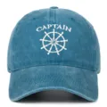 Detail view of washed denim baseball cap featuring white Captain embroidery and wheel. - Adjustable / Lake Blue