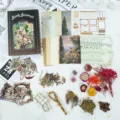Retro junk journal craft kit with background paper, vintage stickers, and dried flowers. - Claws and Petals