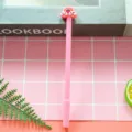 Cute pink gel pen featuring a vibrant cartoon rainbow and cloud topper decoration - 0.5mm Pen Point / Pink